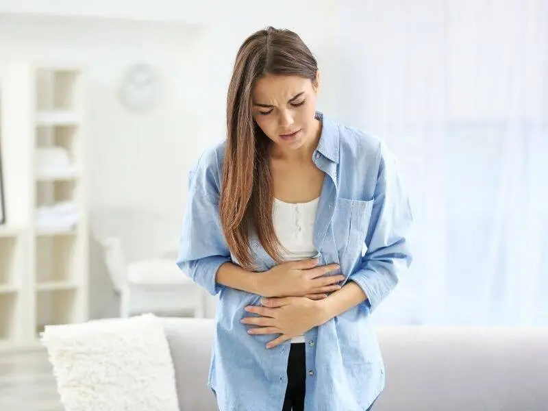 Woman holding her lower abdomen in pain