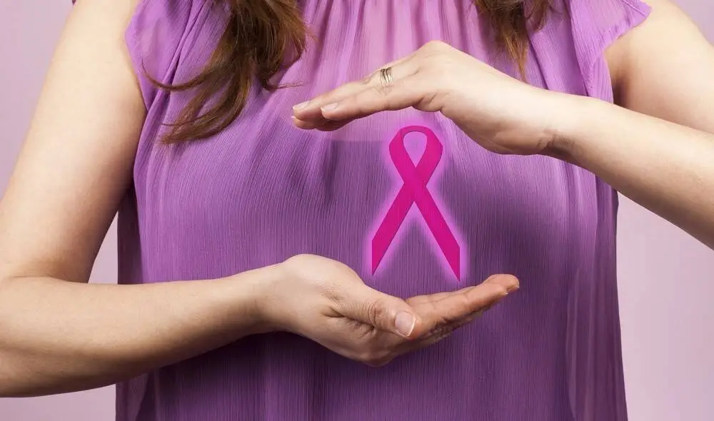 Woman holding a pink breast cancer awareness ribbon
