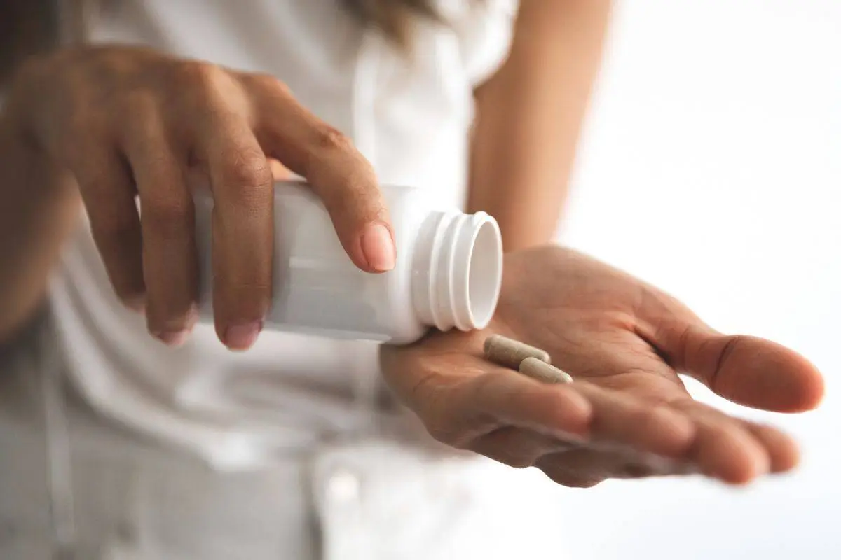 Person pouring prenatal vitamins into their hand