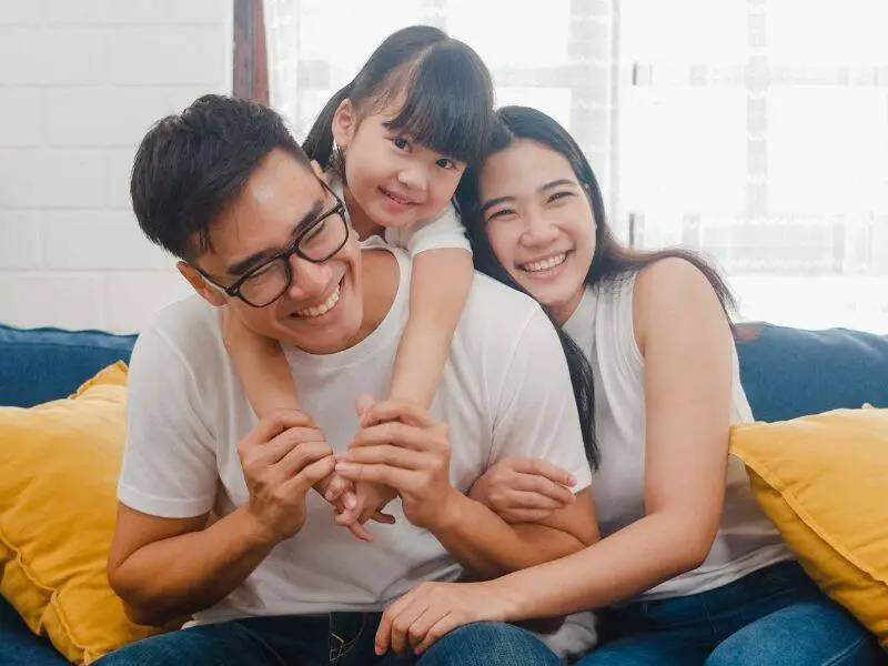 Parents sitting on a couch with their young child